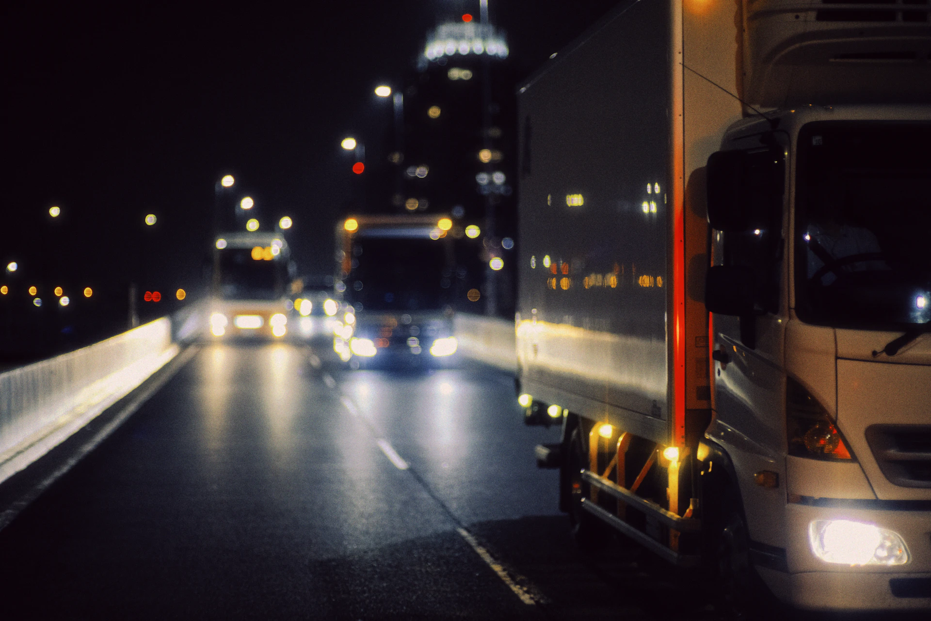 Semi-truck driving down a city street at night