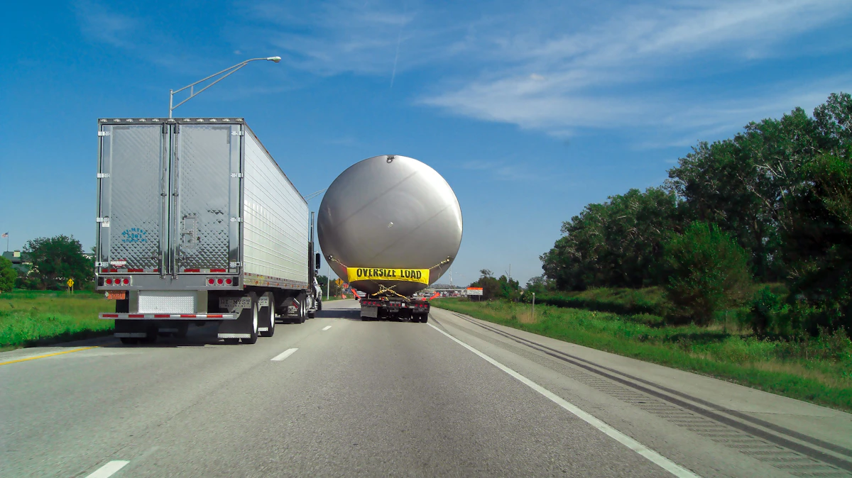 Semi-trucks hauling a large tank load on the highway